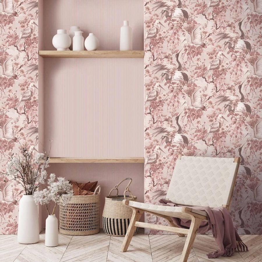 Woodchip & Magnolia Maurice Blush Pink Wallpaper featuring crane birds and blooming branches. Wallpaper is decorating a living area.