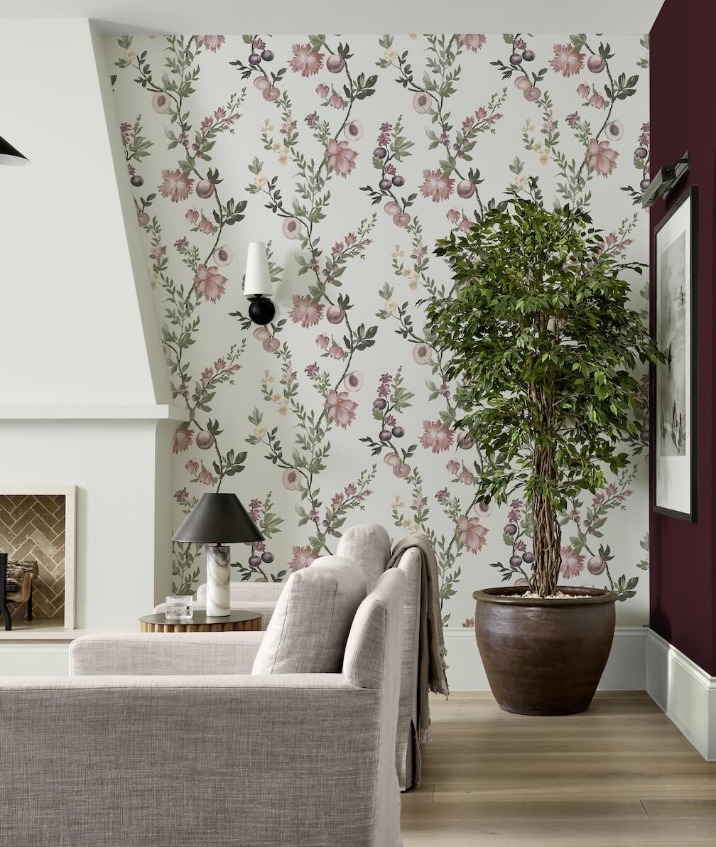 Decor Warehouse Sale up to 25% off wallpaper - Image of a living room decorated in a white wallpaper featuring vertical pink floral trails.