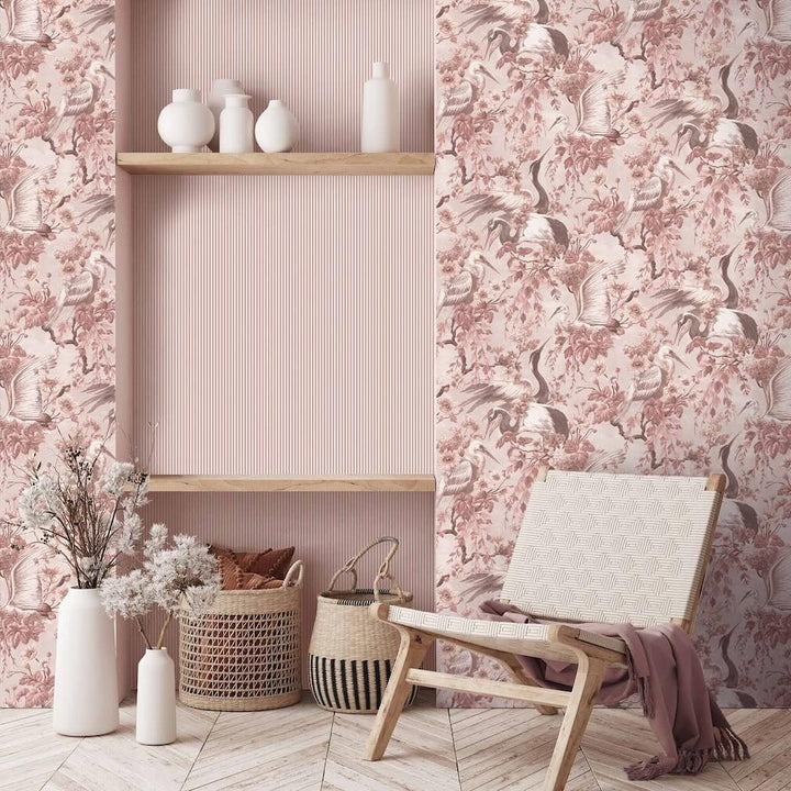 Woodchip & Magnolia Maurice Blush Pink Wallpaper featuring crane birds and blooming branches. Wallpaper is decorating a living area.
